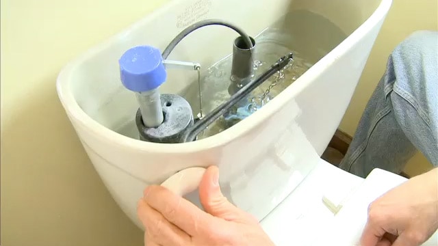 man fixing toilet flush