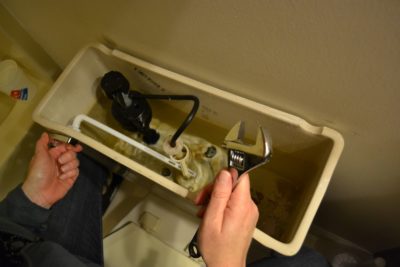 Person fixing the toilet